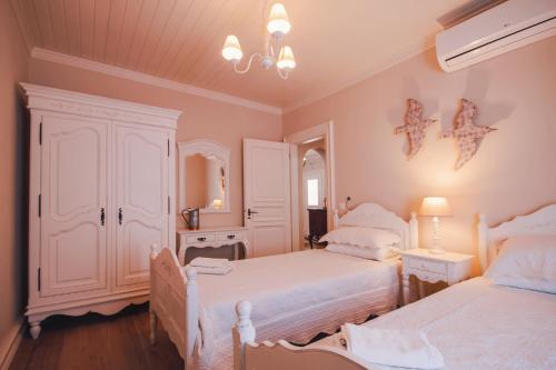 卡拉米The Durrell White House的一间卧室设有两张单人床和一面镜子