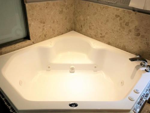 竹北哈密瓜汽车旅馆-竹北馆的浴室配有白色浴缸及水槽
