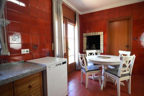 圣卡洛斯拉腊皮塔Casa Bel的厨房配有桌椅和红色瓷砖