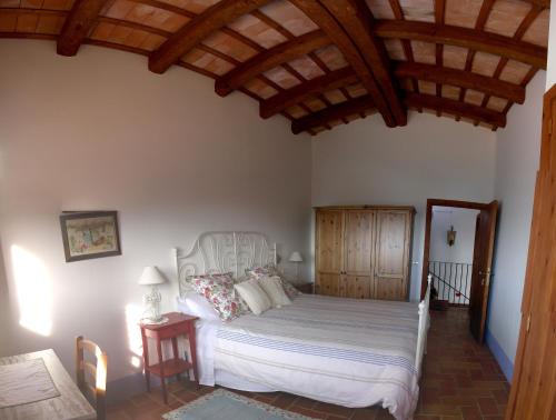 科尔努德利亚Mas del Salin的卧室配有白色床和木制天花板