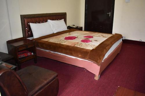 伊斯兰堡Hotel Islamabad Residency的一间卧室配有一张大床和一把椅子