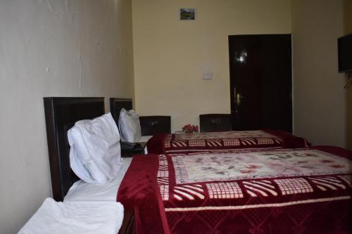 伊斯兰堡Hotel Islamabad Residency的酒店客房带两张红色和白色的床单