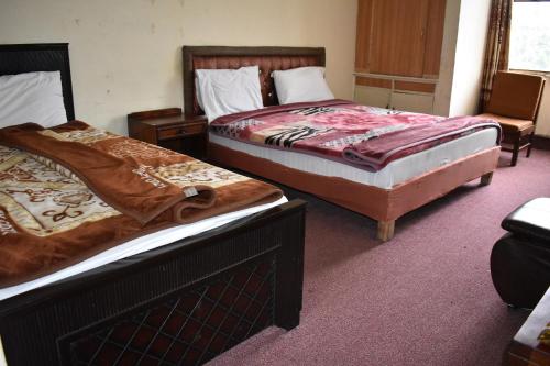 伊斯兰堡Hotel Islamabad Residency的两张睡床彼此相邻,位于一个房间里