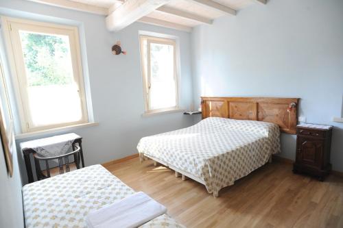 Marmirolo伊尔加迪诺德尔金帝库斯托扎酒店的一间卧室设有两张床和两个窗户。