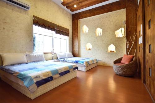 台东台东知本鸟语花香民宿的一间卧室设有两张床和窗户。