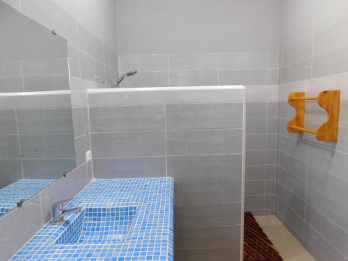斯基灵角CAP BAY的浴室铺有蓝色瓷砖,设有带长凳的淋浴