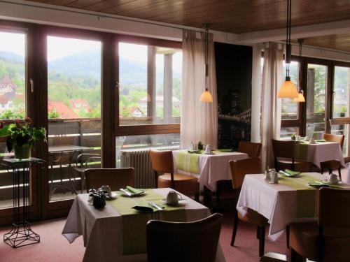 格恩斯巴赫施塔特格贝克酒店的餐厅设有桌椅和大窗户。