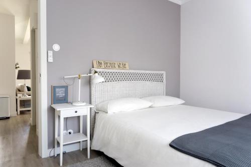 蒙蒂茹Apartamento modeno e acolhedor com terraço的一间白色卧室,配有床和床头柜