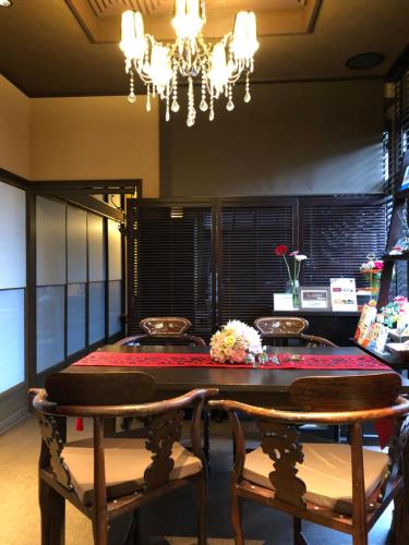 下关Guest House "Ro"kumano的一间带桌椅和吊灯的用餐室