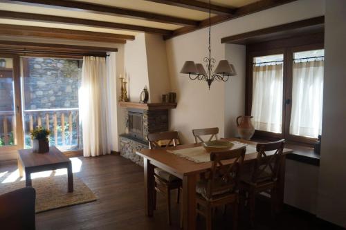 IsilAcogedora casita en el Pallars的一间带桌椅和壁炉的用餐室