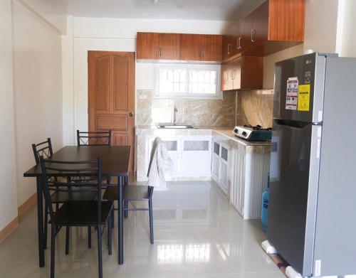 巴旺Gregorio Homes的厨房配有桌子和冰箱