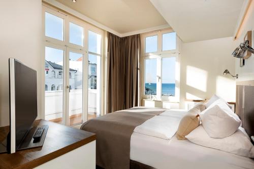 宾茨LOEV - VELA Hotels的一间卧室设有一张床、一台电视和窗户。