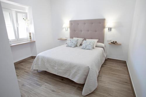 阿尔戈多纳莱斯EL PALOMAR的白色卧室配有一张带两个枕头的大床