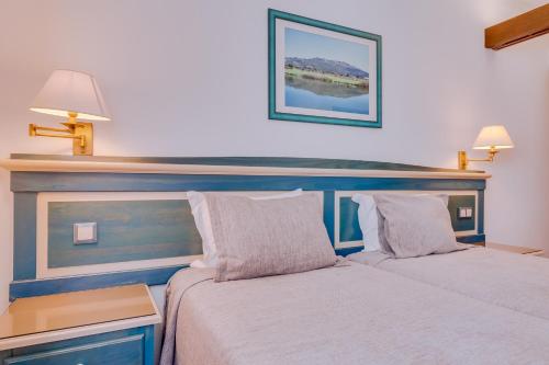 阿尔布费拉海景酒店的一间卧室设有两张床和蓝色床头板