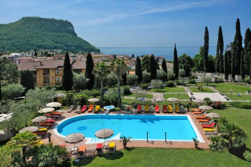 加尔达Villa Madrina Lovely and Dynamic Hotel的享有带椅子和遮阳伞的度假村的游泳池景致