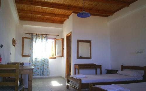 加夫多斯岛Akrogiali的客房设有两张床、一张桌子和一扇窗户。