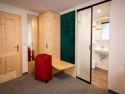 阿特尔高地区圣格奥尔根Siri's Einkehr的一间浴室的房间里装有红色的行李箱