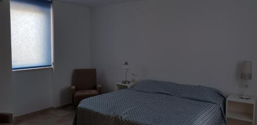 阿尔比尔Camping La Colina的卧室配有床、椅子和窗户。