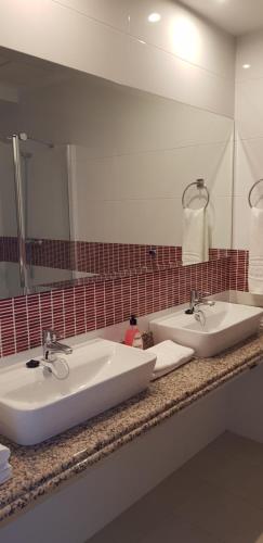 阿尔比尔Camping La Colina的一间带两个盥洗盆和大镜子的浴室