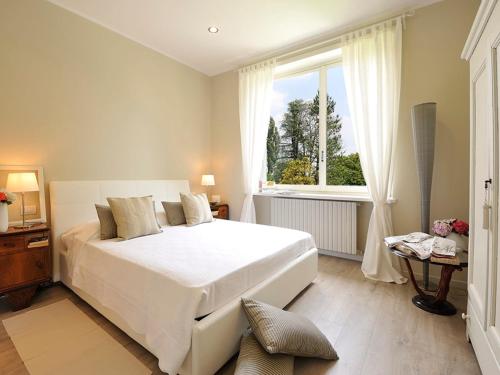里沃利Villa La Maggiorana的卧室设有一张白色大床和一扇窗户。