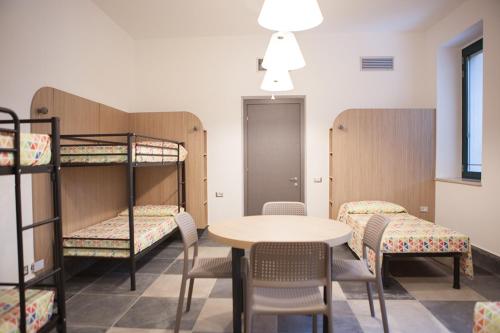都灵Ostello Alfieri 2的客房设有双层床和桌椅。
