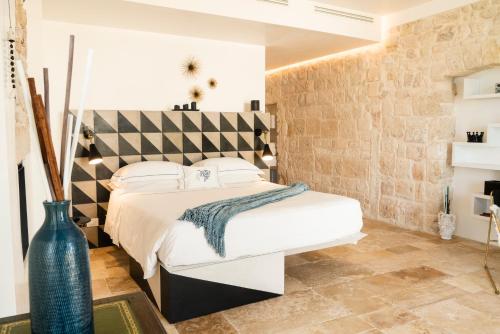 滨海波利尼亚诺Antico Mondo Rooms & Suites的卧室配有白色大床和砖墙