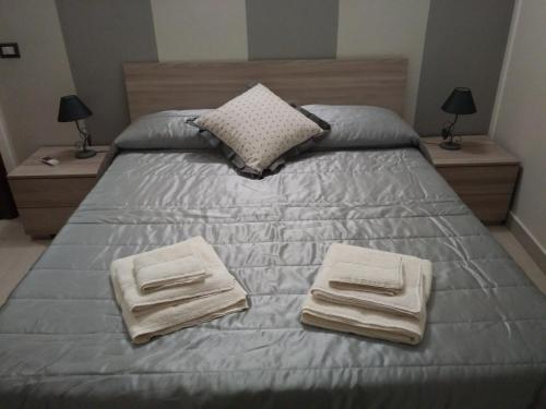 墨西拿Via Roma 12的一张带两条毛巾的床,带两个床头柜