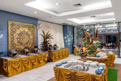 大城大城滨江大酒店的宴会厅设有黄色桌子、盘子和碗