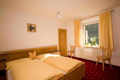 Campodazzo斯特格旅馆的一间卧室设有一张床和一个窗口