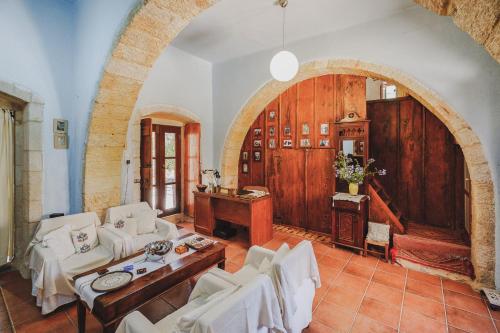 KambánionIconic Cretan Stone Mansion的客厅配有白色家具和拱门