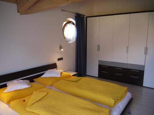 坎波图雷斯Hörtmairhof的一间卧室配有两张带黄床单的床
