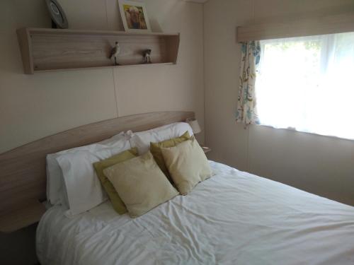 伯顿Borwick Lakes Haven的卧室配有白色的床和2个枕头