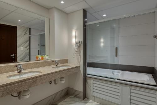 维多利亚维多利亚舒适套房酒店的一间带两个水槽和玻璃淋浴间的浴室