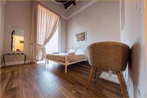 埃尔科拉诺Villa Cua的卧室配有床、椅子和窗户。