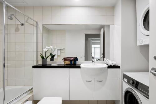 Narre Warren那热华伦探索旅馆的白色的浴室设有水槽和洗衣机。