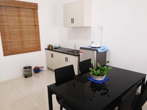 瓜埠Cozy 3 Bedrooms Apartment Langkawi的带黑色桌椅的厨房和带冰箱的厨房