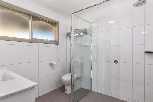 沃加沃加卡里奇豪斯品质酒店的一间带卫生间和玻璃淋浴间的浴室