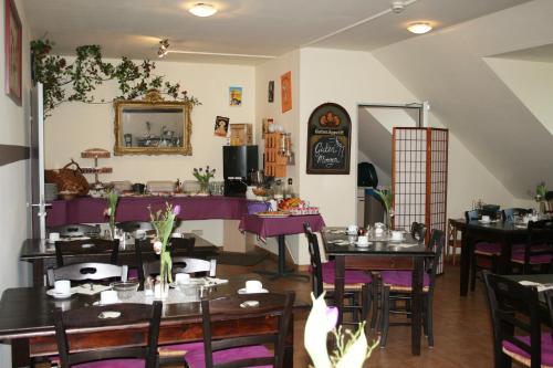 德累斯顿Hotel am Waldschlösschen - Brauhaus的餐厅设有木桌和紫色的桌椅