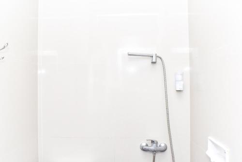 沃诺索博RedDoorz near Alun Alun Wonosobo的浴室内带软管的淋浴