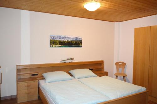 新黎凡特Haus Kohler Bernhard的一间卧室配有一张大床和木制床头板