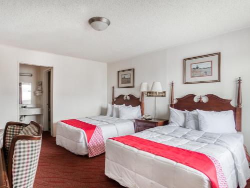 圣安东尼奥OYO Hotel San Antonio East的酒店客房带两张红色和白色的床单