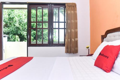 安汶RedDoorz Plus @ Tirta Kencana Hotel的一间卧室设有一张床和一个窗口