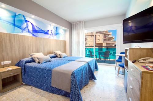奥罗佩萨德尔马Hotel Servigroup Koral Beach的酒店客房,配有床和电视
