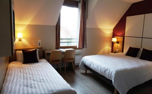 第戎科隆比尔公园餐厅酒店的酒店客房设有两张床、一张桌子和一个窗户。