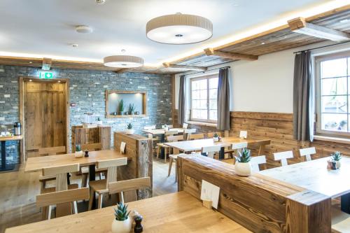 哈斯利伯格如题酒店的餐厅设有木桌和椅子,拥有砖墙