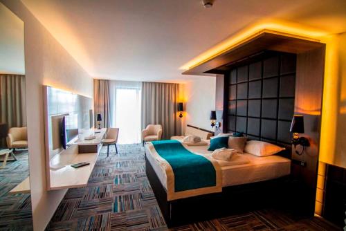萨拉热窝萨拉热窝山会议及温泉Spa酒店的酒店客房设有一张大床和一张书桌。