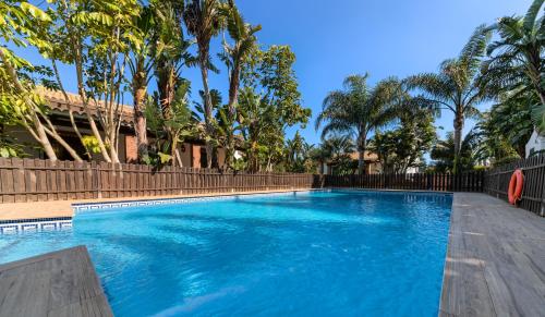 科尼尔-德拉弗龙特拉罗氏维霍德庄园乡村民宿的一座拥有蓝色海水和棕榈树的游泳池