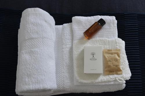 克拉科夫Castle View Boutique Apartment的白色毛巾,包括一瓶肥皂和一支香烟