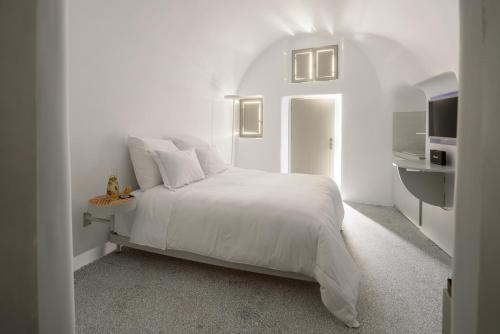 伊亚Echoes Luxury Suites的白色卧室设有白色的床和厨房