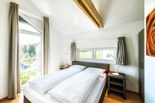 TruppachPanoramahaus _100_ im Feriendorf a的一间卧室设有一张床和一个大窗户